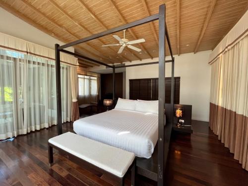 a bedroom with a bed and a ceiling fan at Amatapura Beachfront Villa 10 , SHA Certified in Ao Nam Mao