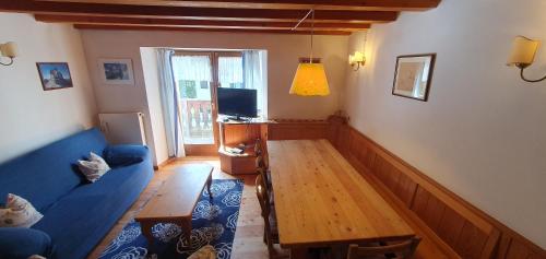 a living room with a blue couch and a table at Rustico nelle Dolomiti in Val di Zoldo