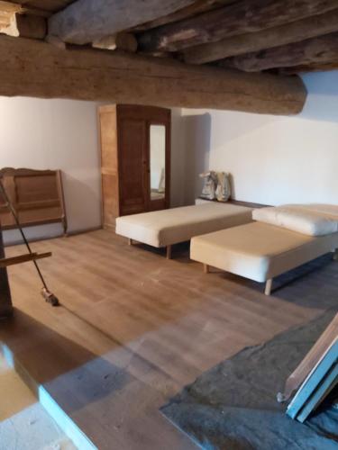 - un salon avec 2 lits et du parquet dans l'établissement Maison charmante à Lanarce avec vue sur la montagne, jacuzzi., à Lanarce