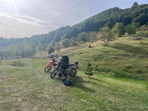 dos motos estacionadas en un campo en una colina en Jezerina en Šavnik