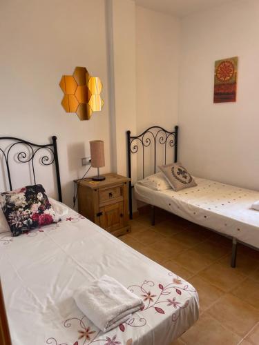 - une chambre avec deux lits et une table avec une lampe dans l'établissement Bright & Airy Sea View Apartment, à Mojácar