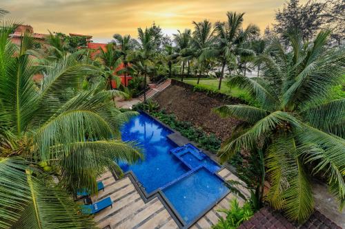 an overhead view of a swimming pool with palm trees at Mandrem Beach Resort, a member of Radisson Individuals Retreat in Mandrem
