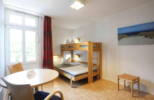 a small room with a bunk bed and a table at Jugendherberge Kiel in Kiel