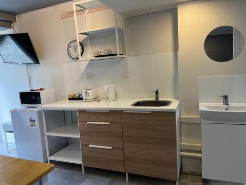 una pequeña cocina con fregadero y microondas en Airway Motel en Brisbane