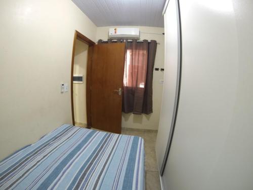 mały pokój z łóżkiem i drzwiami w obiekcie Casa Rota das 3 Fronteiras w Foz do Iguaçu