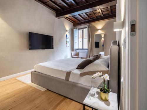 1 dormitorio con 1 cama grande y TV de pantalla plana en Santa Croce Luxury Suite - Dolcevita Holiday en Florence