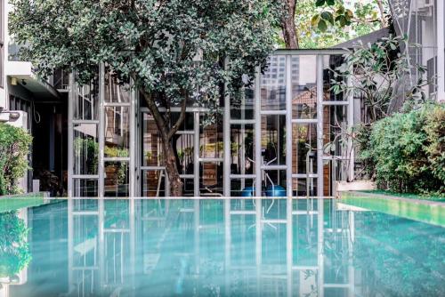 una piscina frente a un edificio con árboles en BTS 46 - Near BTS Phrakhanong, en Bangkok