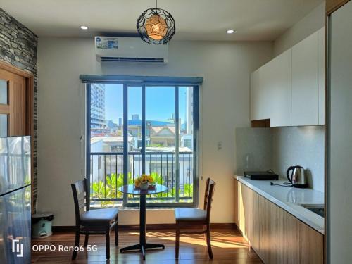 uma cozinha com uma mesa com cadeiras e uma varanda em Tree Homestay em Da Nang
