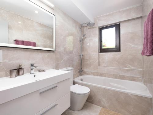 e bagno con lavandino, servizi igienici e vasca. di Marble Heights, 2bed Luxury Apt a Kouklia