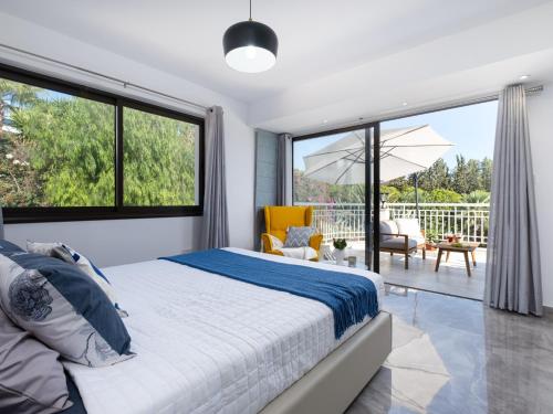 Schlafzimmer mit einem Bett und großen Fenstern in der Unterkunft Marble Heights, 2bed Luxury Apt in Kouklia