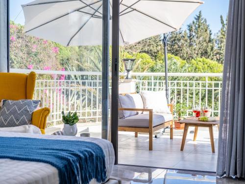 a bedroom with a bed and an umbrella at Marble Heights, 2bed Luxury Apt in Kouklia