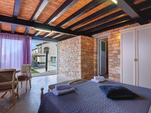 a bedroom with a bed and a brick wall at Villa in Rovinj with Pool and Sauna in Rovinjsko Selo