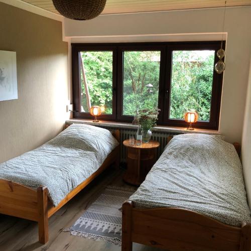 2 Betten in einem Zimmer mit Fenster in der Unterkunft Unter Den Eichen in Bötersen