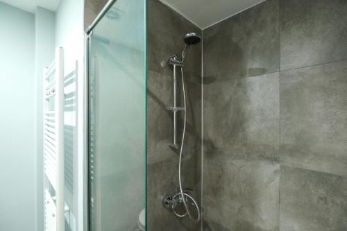 a shower with a glass door in a bathroom at Luminous Flat 7 min to Arcadium Mall in Ankara in Ankara