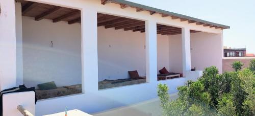 a patio with couches on a white wall at Dar Afoulky Maison D'hotes in Sidi Kaouki