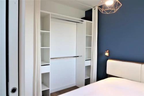 BEAUTIFUL DAY RUEIL - 1 chambre - 4 Pers - Wifi في روي-مالميزون: غرفة نوم مع خزانة مع سرير وجدار أزرق