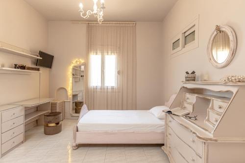 a white bedroom with a bed and a mirror at Black Velvet in Agkidia