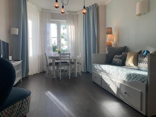 a bedroom with a bed and a table and a dining room at AquaGate Jurmala in Jūrmala