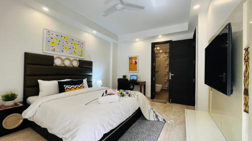 Schlafzimmer mit einem großen Bett mit einem schwarzen Kopfteil in der Unterkunft Olive Service Apartments - Greater Kailash in Neu-Delhi