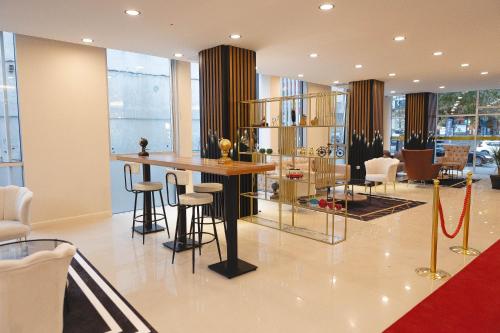 a lobby with a bar with stools and chairs at City Night Suites & Hotels in Çekme