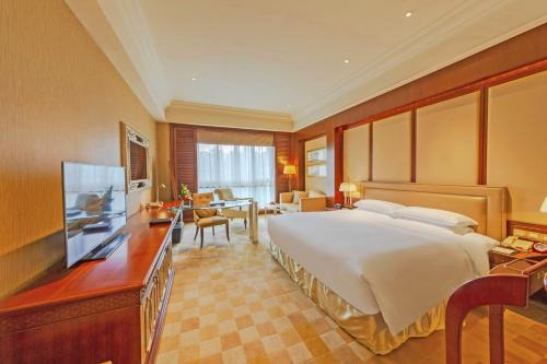 a hotel room with a large bed and a television at Shanghai Dongjiao State Guest Hotel in Shanghai