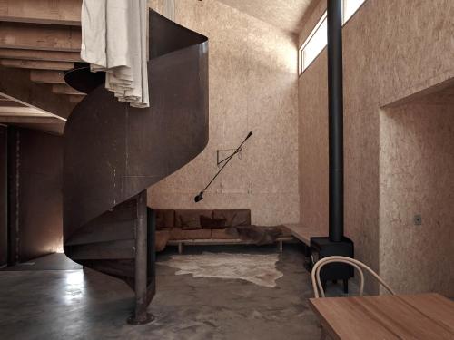 a spiral staircase in a room with a table at Ross Farm - Barn in Meeniyan