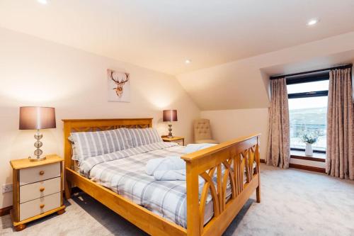 a bedroom with a wooden bed and a large window at The Barn @ Clauchan holiday Cottages in Gatehouse of Fleet