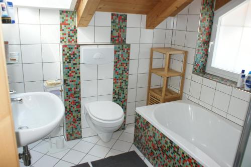 La salle de bains est pourvue de toilettes, d'une baignoire et d'un lavabo. dans l'établissement Haus am Lahnbach, à Schwaz