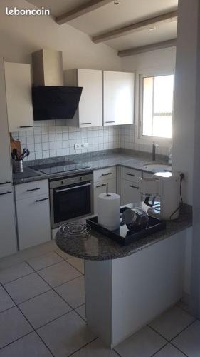 a kitchen with white cabinets and a counter top at le Rempart in Grignan