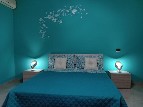 1 dormitorio azul con 1 cama grande y 2 lámparas en Al primo piano 22, en Castrovillari