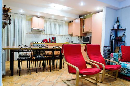 cocina con mesa de comedor y sillas rojas en Holiday Vila Predeal en Predeal