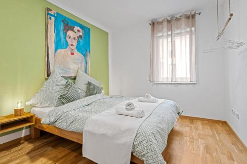 um quarto com uma cama com um quadro na parede em Smurmelhomes Oase: Terrasse - Parken - Kind em Passau