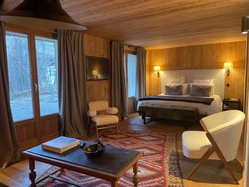 una habitación de hotel con una cama, una mesa y sillas en RED LODGE, en Megève