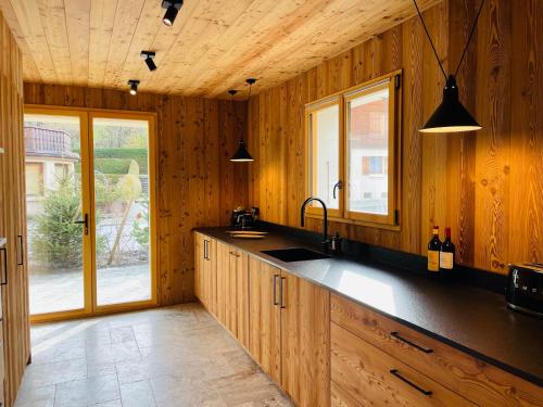Una cocina con paredes de madera y una encimera con fregadero. en RED LODGE, en Megève