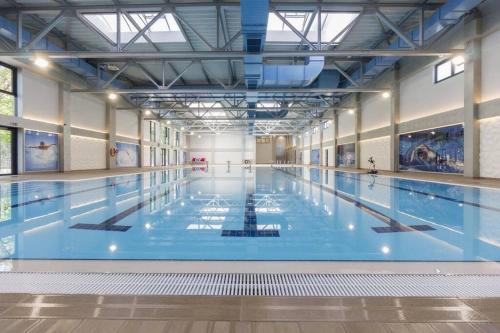 ein großes Hallenbad mit blauem Wasser in der Unterkunft Lux Apartman Crnjanski IV, Jagodina in Jagodina