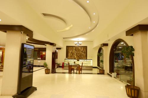 Un vestíbulo con una mesa y sillas en un edificio. en Breeze Residency, en Tiruchchirāppalli