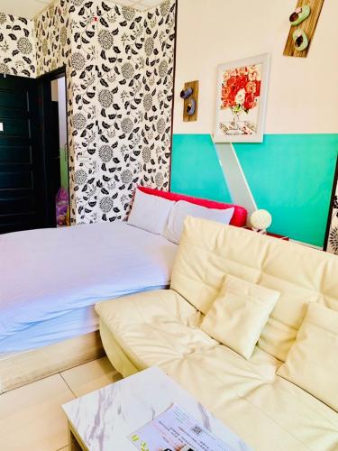 a living room with a couch and a bed at Aliya阿利亞 in Huwei