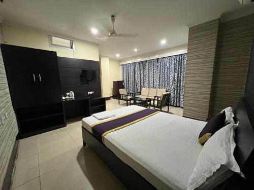 a bedroom with a bed and a living room at Hotel Bluemoon in Guwahati