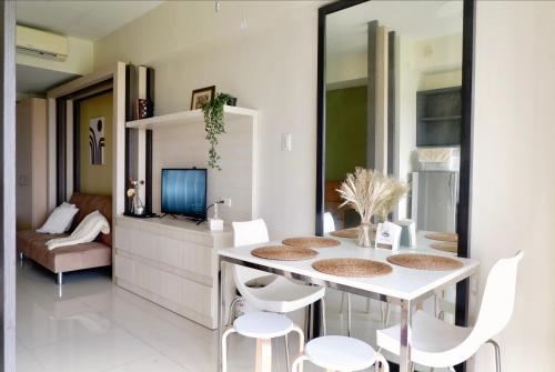 una sala da pranzo con tavolo e sedie bianchi di Wind and Sea at Wind Residences a Tagaytay