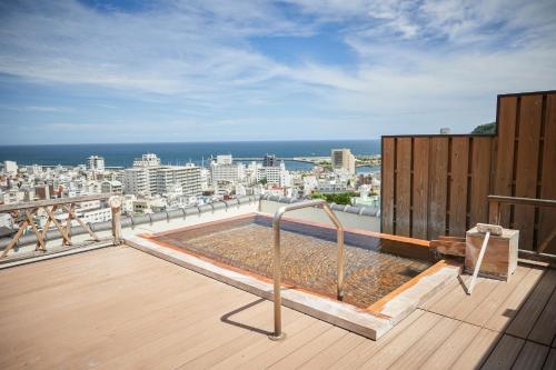 a hot tub on the roof of a building at Shin Kadoya in Atami