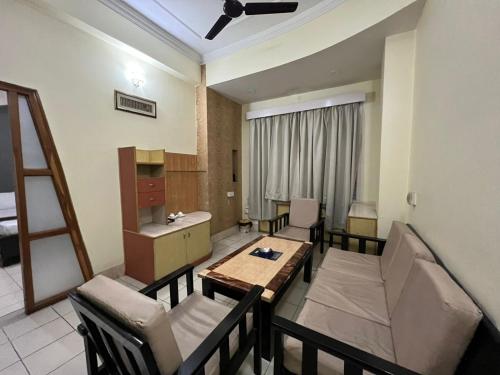 古瓦哈提Hotel Bluemoon的带餐桌和椅子的客厅