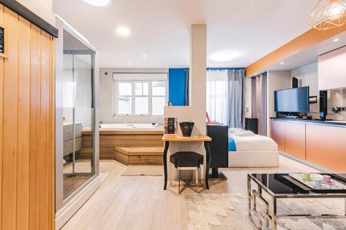 Il comprend un salon avec une cuisine et une chambre. dans l'établissement MV Suite & Spa, à Reims