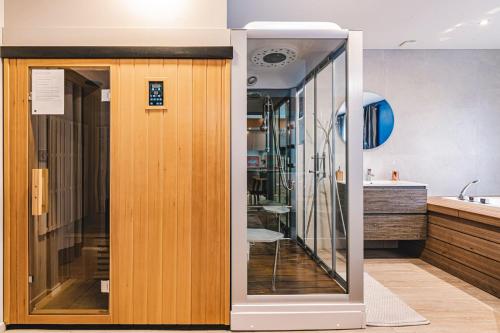 a bathroom with a wooden door and a sink at MV Suite & Spa in Reims