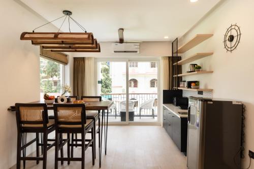 eine Küche mit einem Tisch und Stühlen sowie einem Kühlschrank in der Unterkunft Calangute Heights by Stay ALYF - Luxury 1 BHK Apartments, Calangute in Calangute
