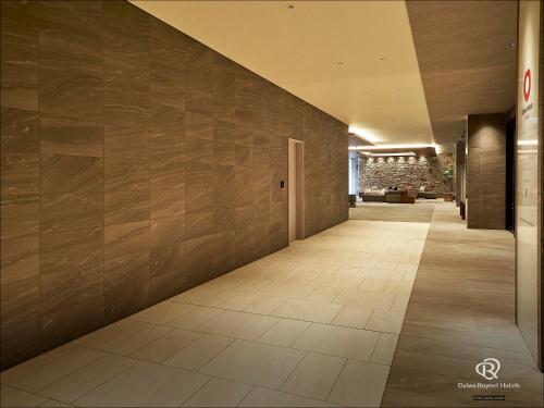 a hallway with a tile floor and a wall at Daiwa Roynet Hotel KOBE-SANNOMIYA PREMIER in Kobe