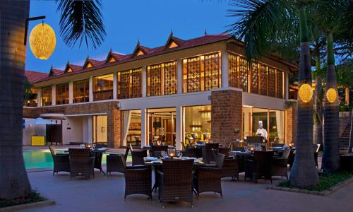 a restaurant with tables and chairs in front of a building at The Golkonda Resort and Spa in Hyderabad