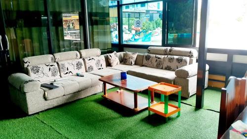a living room with a couch and a coffee table at Bouasavan Hotel and Garden in Savannakhet