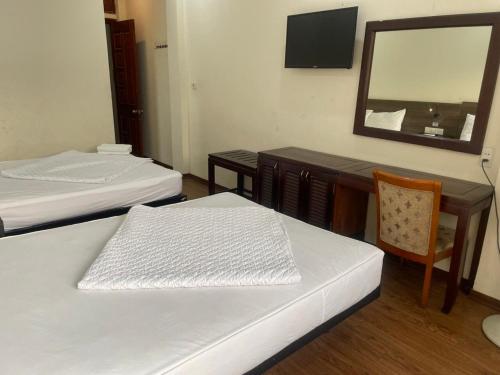 a room with two beds and a table and a mirror at YÊN HÒA MOTEL in Hanoi