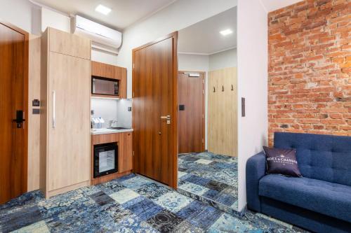 a living room with a blue couch and a brick wall at Apartamenty Browar Luxury Old Town Poznań Check In 24h in Poznań