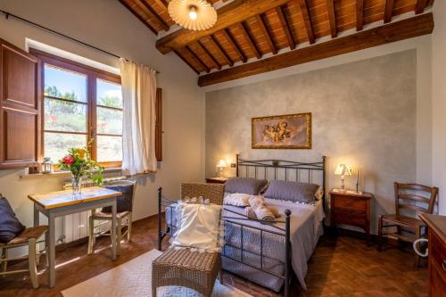 um quarto com uma cama, uma mesa e cadeiras em La Pievina em Montepulciano
